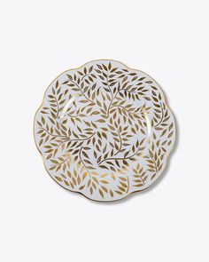 a white and gold plate with leaves on it