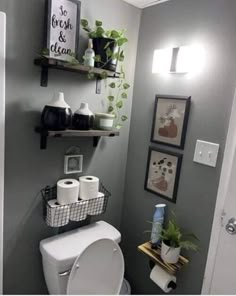 the bathroom is decorated in gray and white with pictures on the wall above the toilet