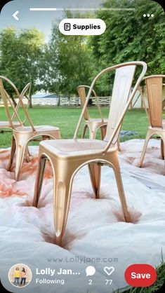 three chairs sitting on top of a blanket in the grass