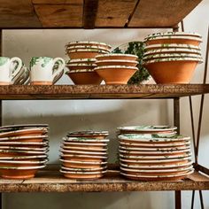 plates and cups are stacked on a shelf