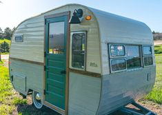 an old trailer is parked in the grass