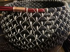 a close up of a woven basket with a wooden stick in the middle of it