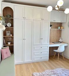 a room with white furniture and wooden flooring is shown in this image, there are several shelves on either side of the closet