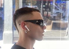 a man wearing sunglasses and piercings on his ears