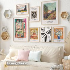 a living room filled with lots of pictures on the wall above a white couch covered in pillows