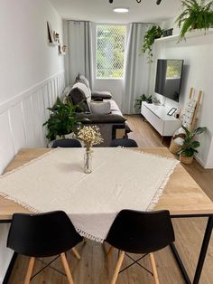 a dining table with chairs and a vase on it