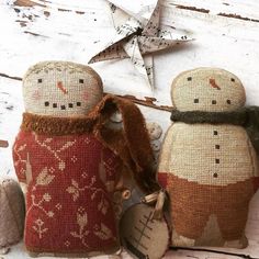 two snowmen made out of burlocks sitting on top of a wooden table