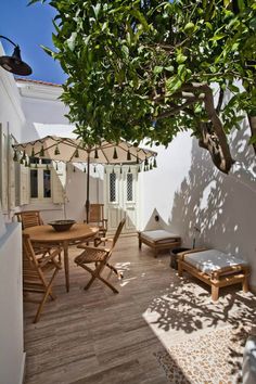 an outdoor patio with wooden furniture and umbrellas