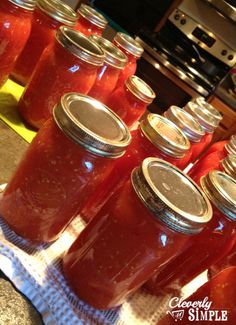 several jars filled with red liquid sitting on top of a counter next to an oven