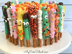 a white plate topped with lots of different colored candy sticks covered in googly eyes