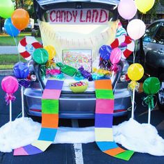 the trunk of a car decorated with candy bars and balloons