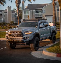 a gray toyota truck parked in front of some palm trees