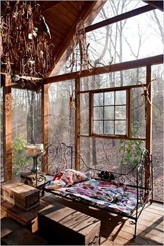 a bed sitting in the middle of a room under a window next to a bench