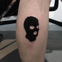 a person with a black skull tattoo on their leg