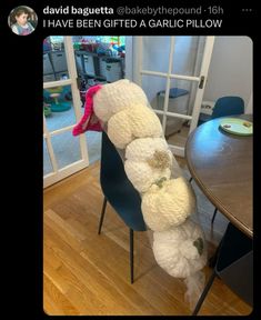 a stuffed animal is sitting on a chair in the middle of a dining room table