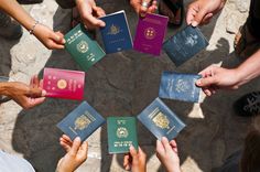 several people are holding their passport in the middle of a circle