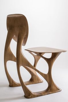 two wooden tables with curves on the sides, one is shaped like an elephant's tail