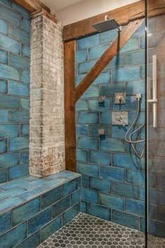 a bathroom with blue tiles on the walls and floor, along with a walk in shower