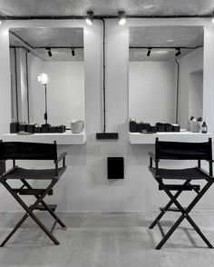 two black and white chairs in front of mirrors