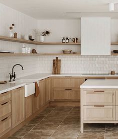 a large kitchen with wooden cabinets and white counter tops, along with tile flooring