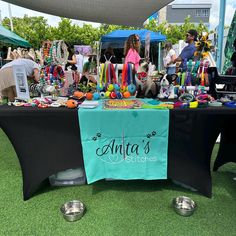 there is a table that has many items on it and people are standing around the table