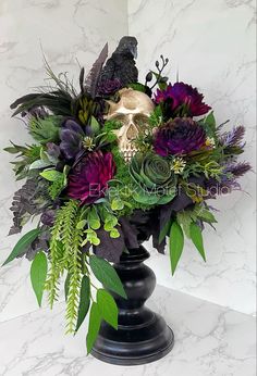 there is a vase with flowers and a skull in it