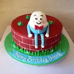 a birthday cake is decorated with an image of a man sitting on a brick wall