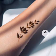 a close up of a person's arm with leaves on it