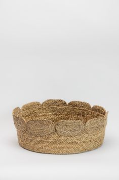 a round basket made out of jute with circles on the bottom and sides, sitting in front of a white background