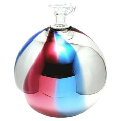 a multicolored glass vase sitting on top of a white table