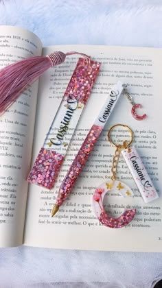 the book is open and has two keychains on it, one with a tassel