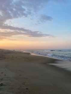 footprints in the sand on an empty beach