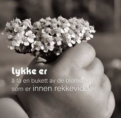 a person holding flowers in their hand with the words lykke er