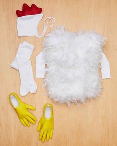 an assortment of toys including gloves, mittens and dress - up clothes are laid out on a wooden surface