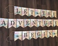 the words let the adventure begin written in cut out letters on a wooden floor with string