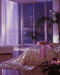 a bedroom with a large window overlooking the city at night, and lit up by candles