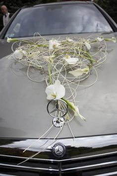 flowers are tied to the hood of a car