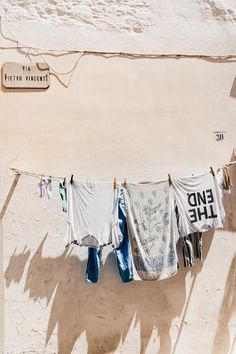 clothes hanging out to dry in the sun on a line next to a sign that says end the day