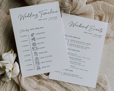 two wedding program cards sitting on top of a bed next to a white orchid flower