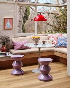 a living room filled with furniture and a red lamp on top of a wooden table