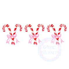 three candy canes with pink bows on them