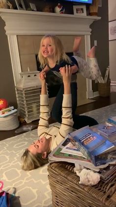 two women laying on the floor in front of a tv with their feet up and arms out