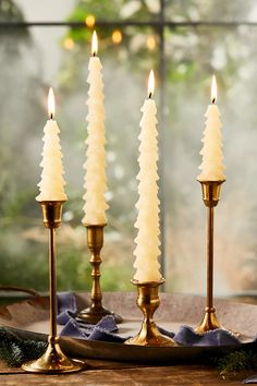 three white candles are sitting on a table