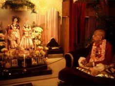 a man sitting in a chair next to a group of figurines on display