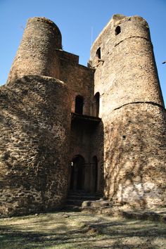 an old stone castle with stairs leading up to the top and side walls, on a sunny day