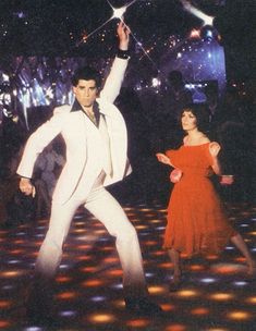 two people on a dance floor with lights in the background and one person holding up a star