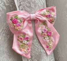 a close up of a pink bow with flowers on it