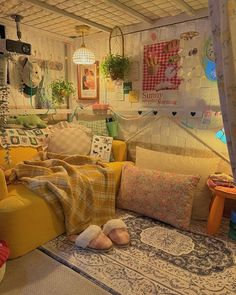 a living room filled with lots of pillows and blankets on top of a rug covered floor