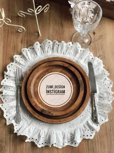 a white doily with a wooden plate and silverware sitting on top of it