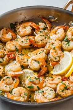 a skillet filled with shrimp and lemon slices